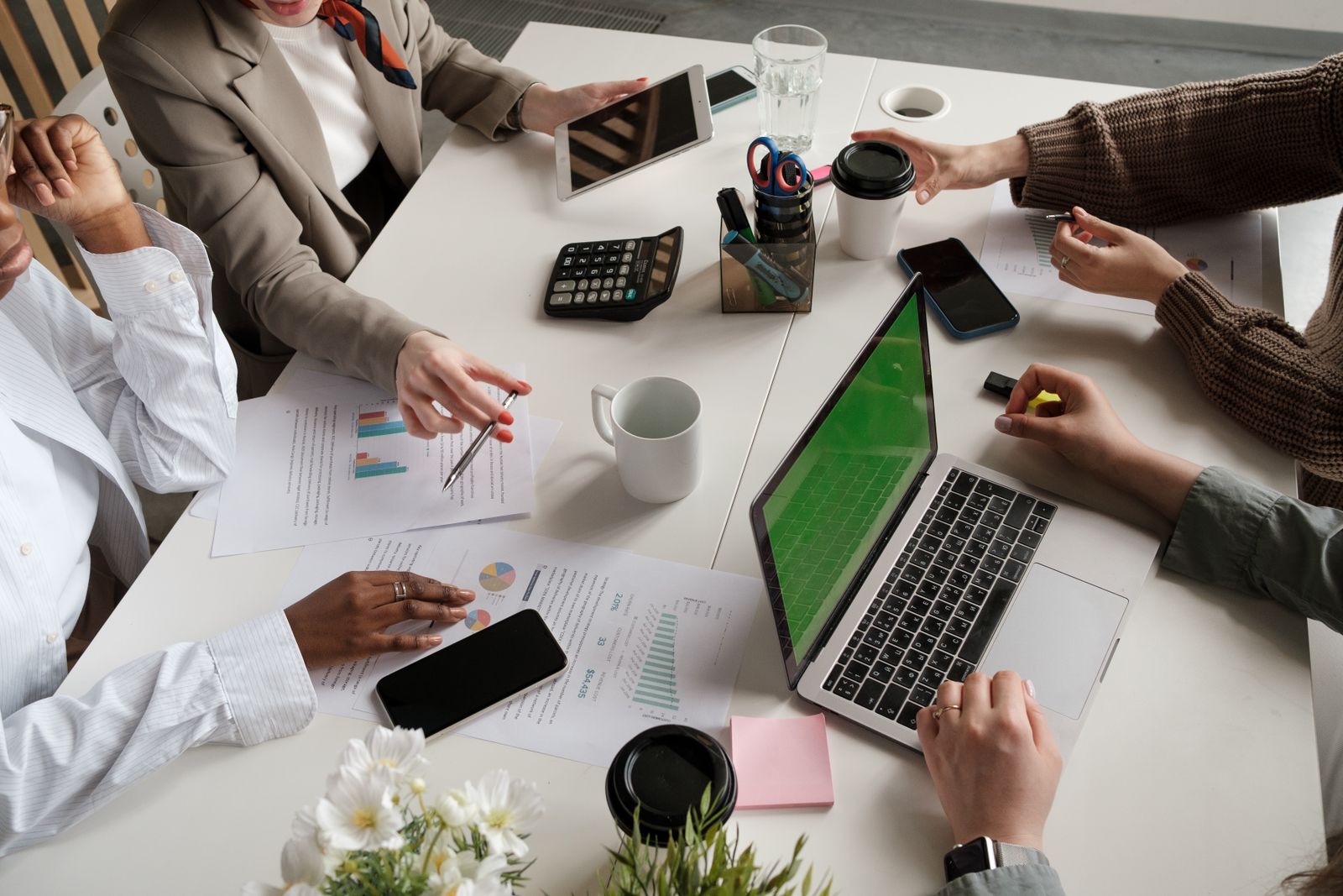 Equipo colaborando alrededor de una mesa para revisar una implementación tecnológica